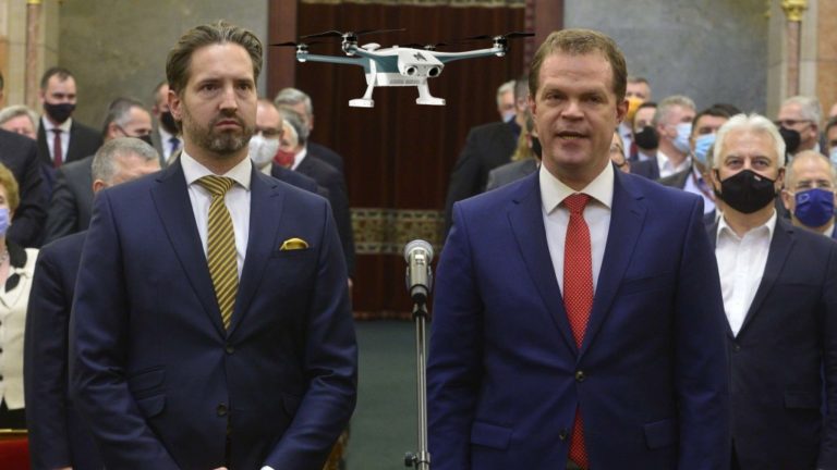 Montázs. Koltay András, a Nemzeti Média- és Hírközlési Hatóság (NMHH) Médiatanácsának megválasztott új elnöke (j) esküt tesz, mellette Bartóki-Gönczy Balázs, a Médiatanács új tagja (b) az Országgyûlés plenáris ülésén 2021. december 14-én. Mögötte Semjén Zsolt miniszterelnök-helyettes (hátul, j) és egy drón.