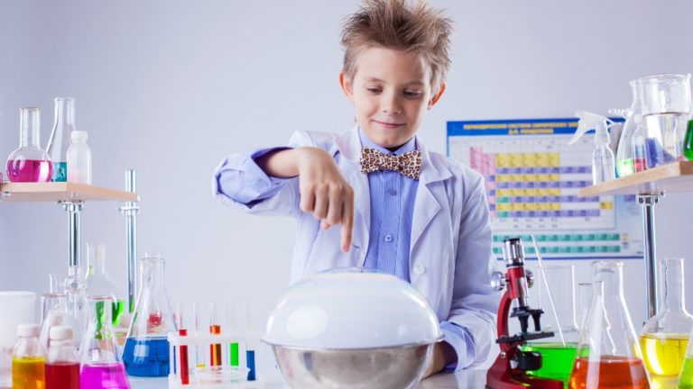Ifjú, gyermekkorú tudós kísérletet végez egy kémialaborban.