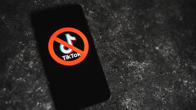 A TikTok áthúzott logoja egy okostelefon kijelzőjén.