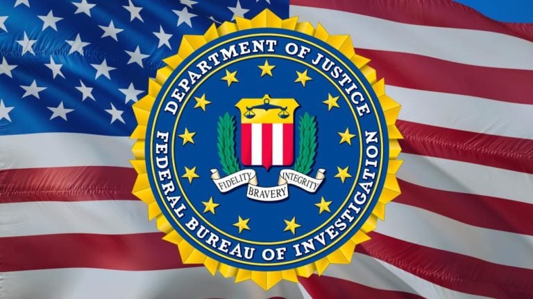 Az FBI emblémája egy amerikai zászló előtt.
