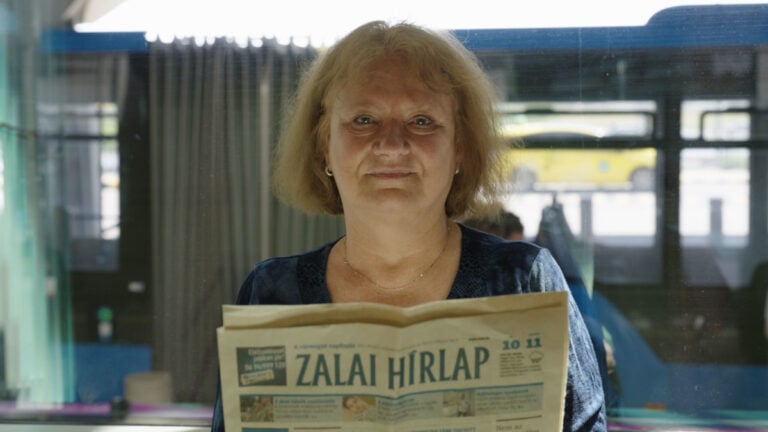 A DW Magyar riportjában megszólaló Zsuzsa, kezében a Zalai Hírlappal